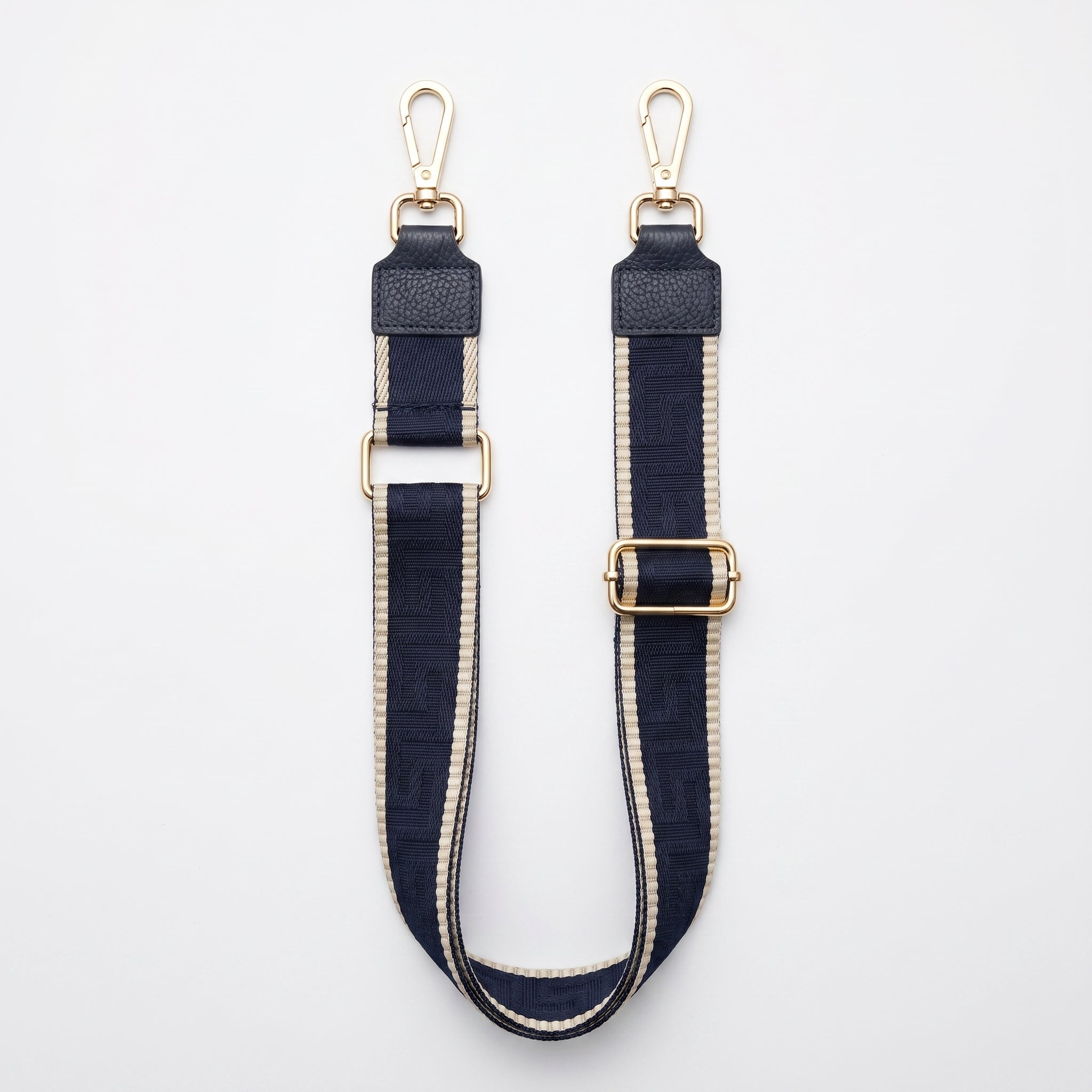 Navy blue and beige strap with gold hardware on a white background