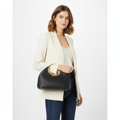 Woman holding a black handbag with gold handle on a white background