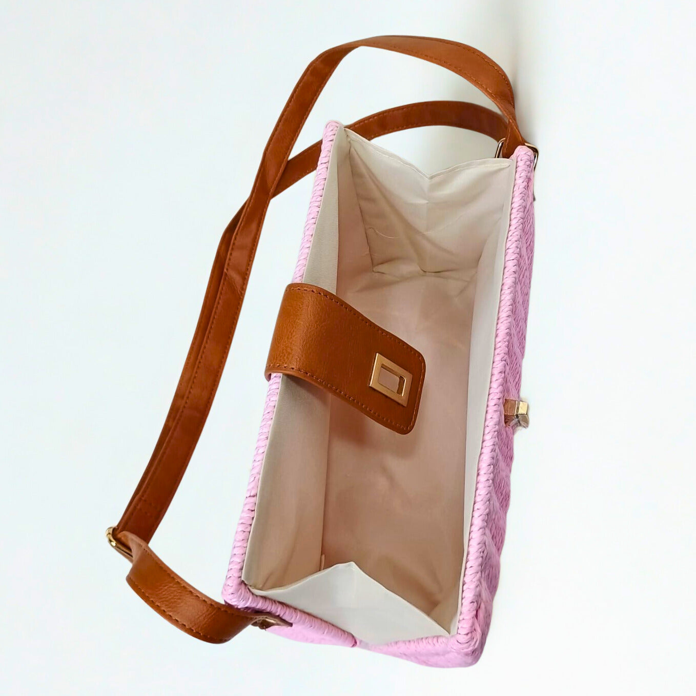 Pink bag with brown strap and trim on a white background