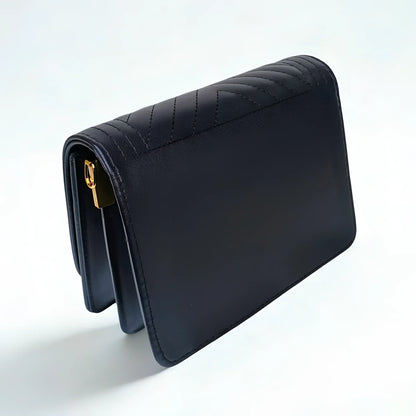 Black quilted handbag on a white background