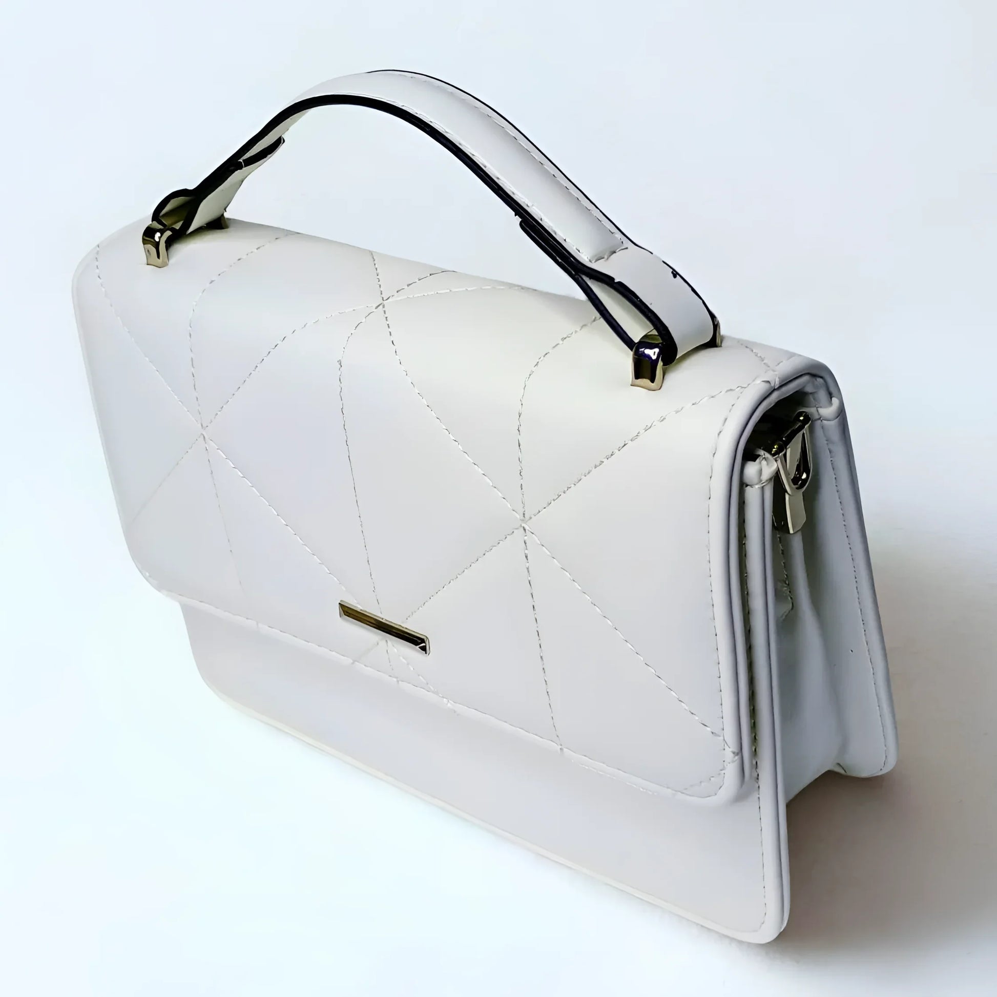 White quilted handbag with gold accents on a light gray background