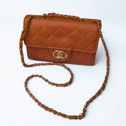Brown quilted handbag with gold chain strap on a white background