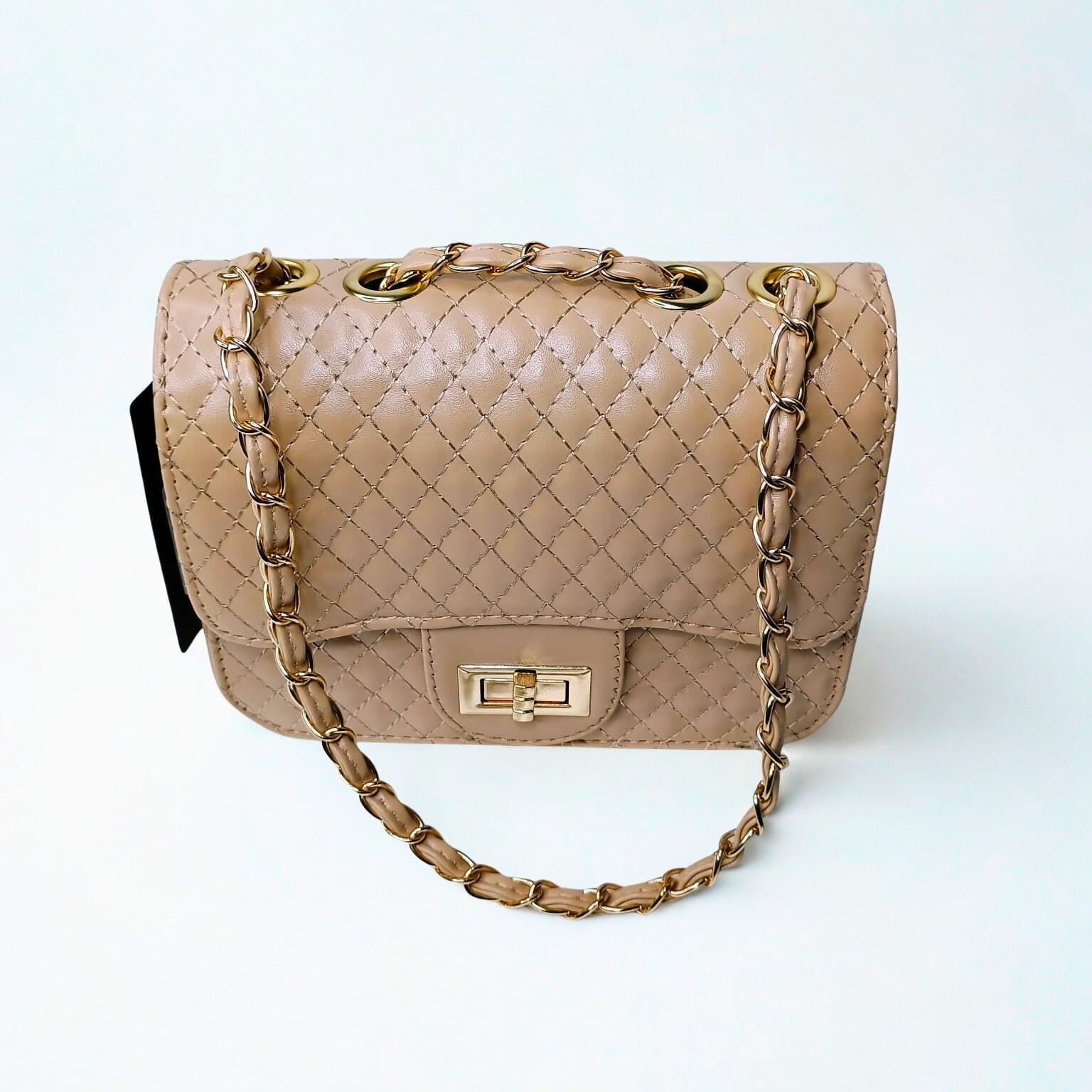 Beige quilted handbag with gold chain strap on a white background