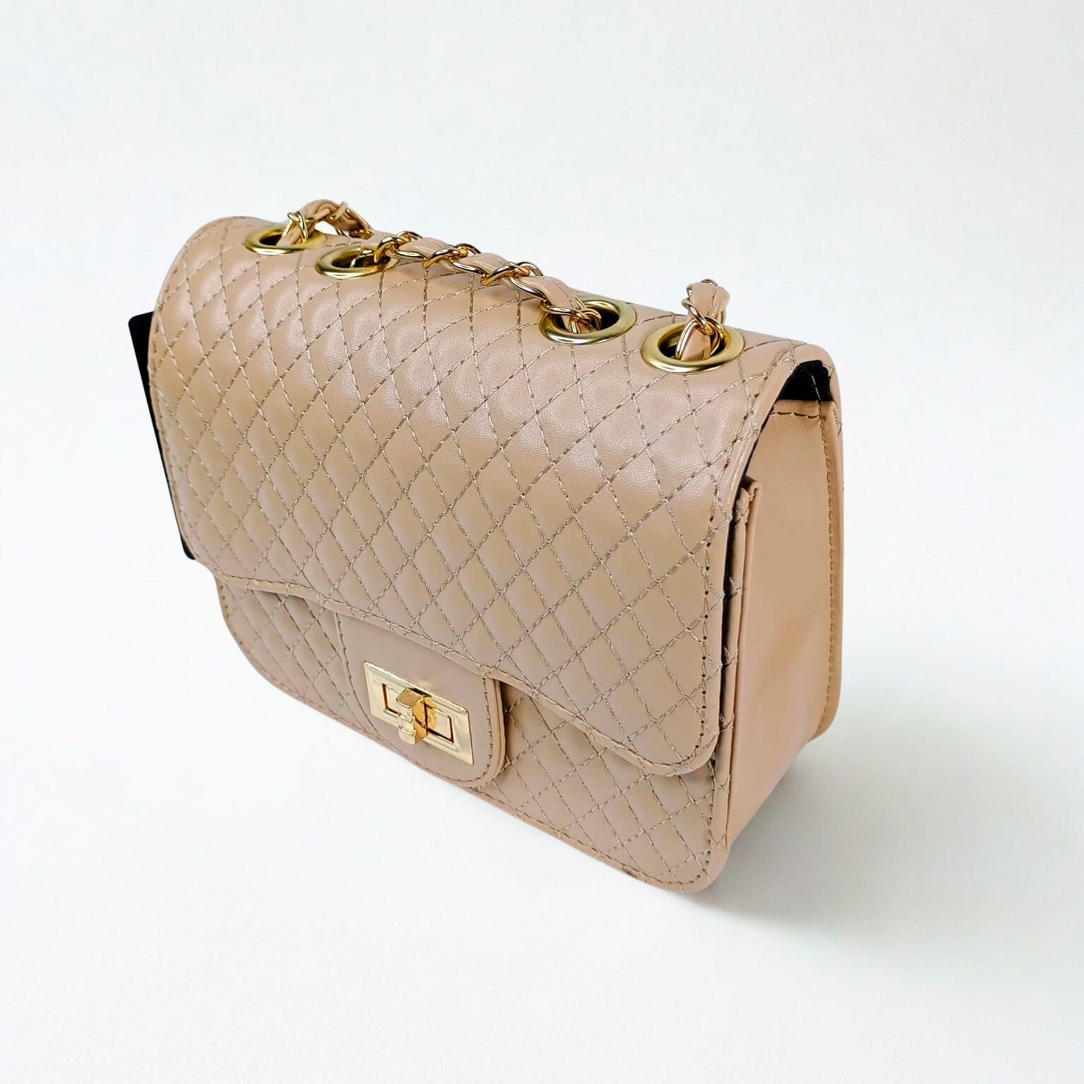 Beige quilted handbag with gold accents on a white background