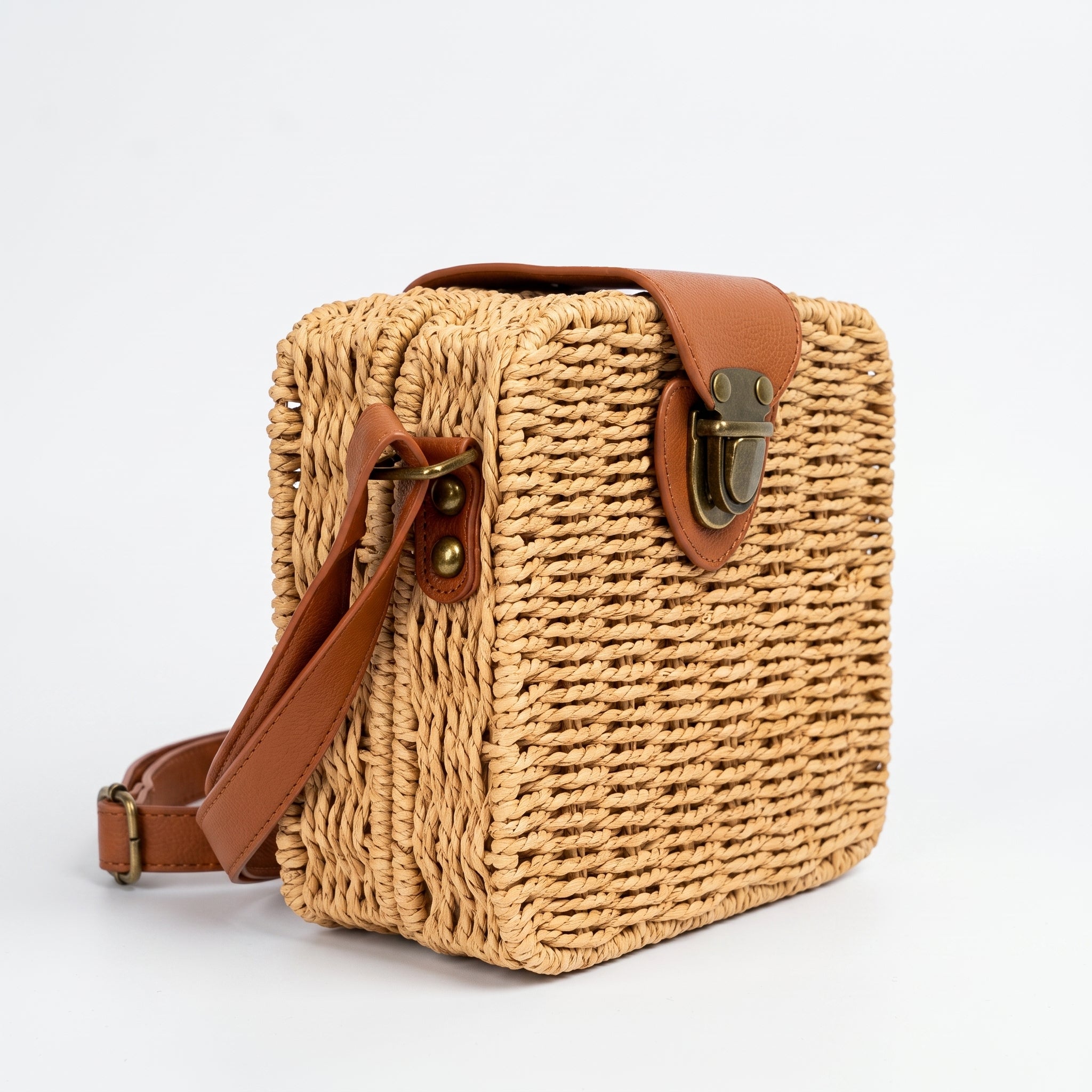 Woven handbag with brown leather accents on a white background