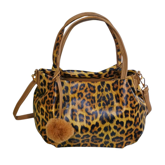 Leopard print handbag with a brown pom-pom on a white background