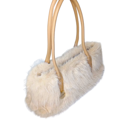 Furry handbag with gold handles on a white background