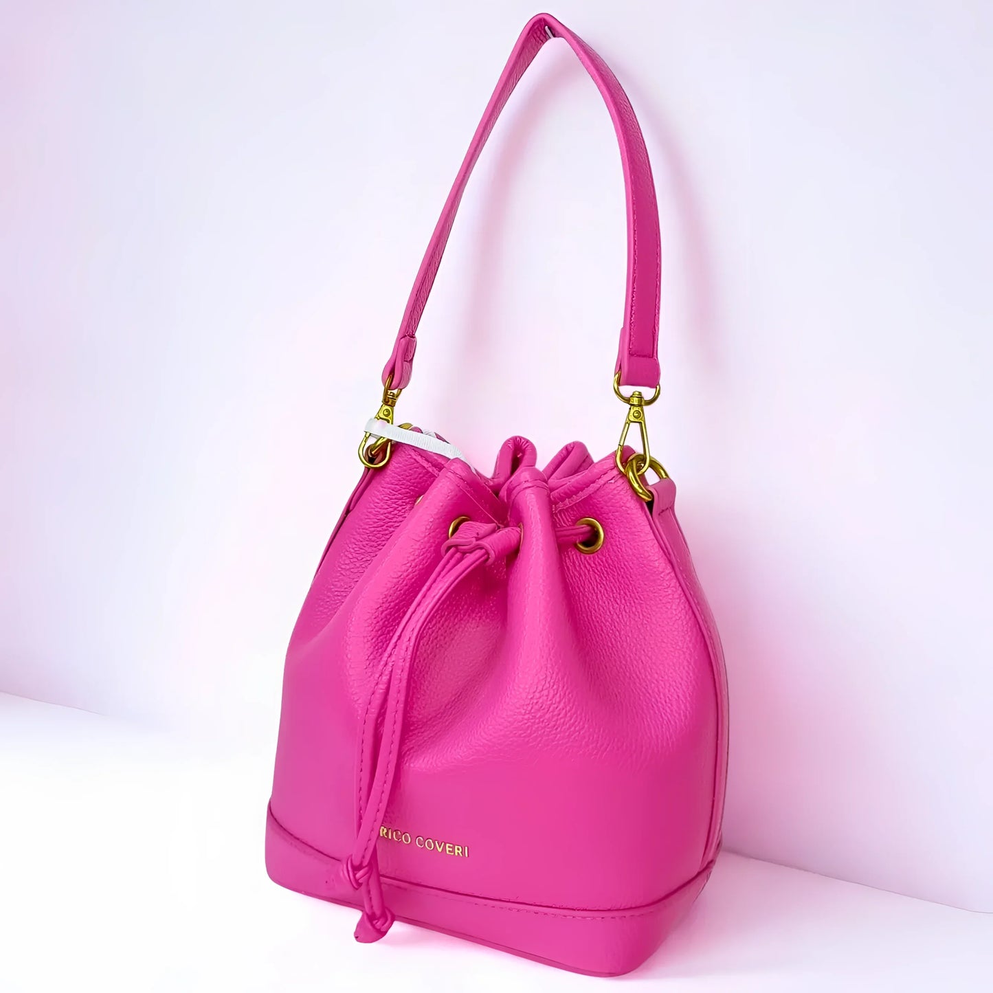 Pink handbag with gold accents on a white background
