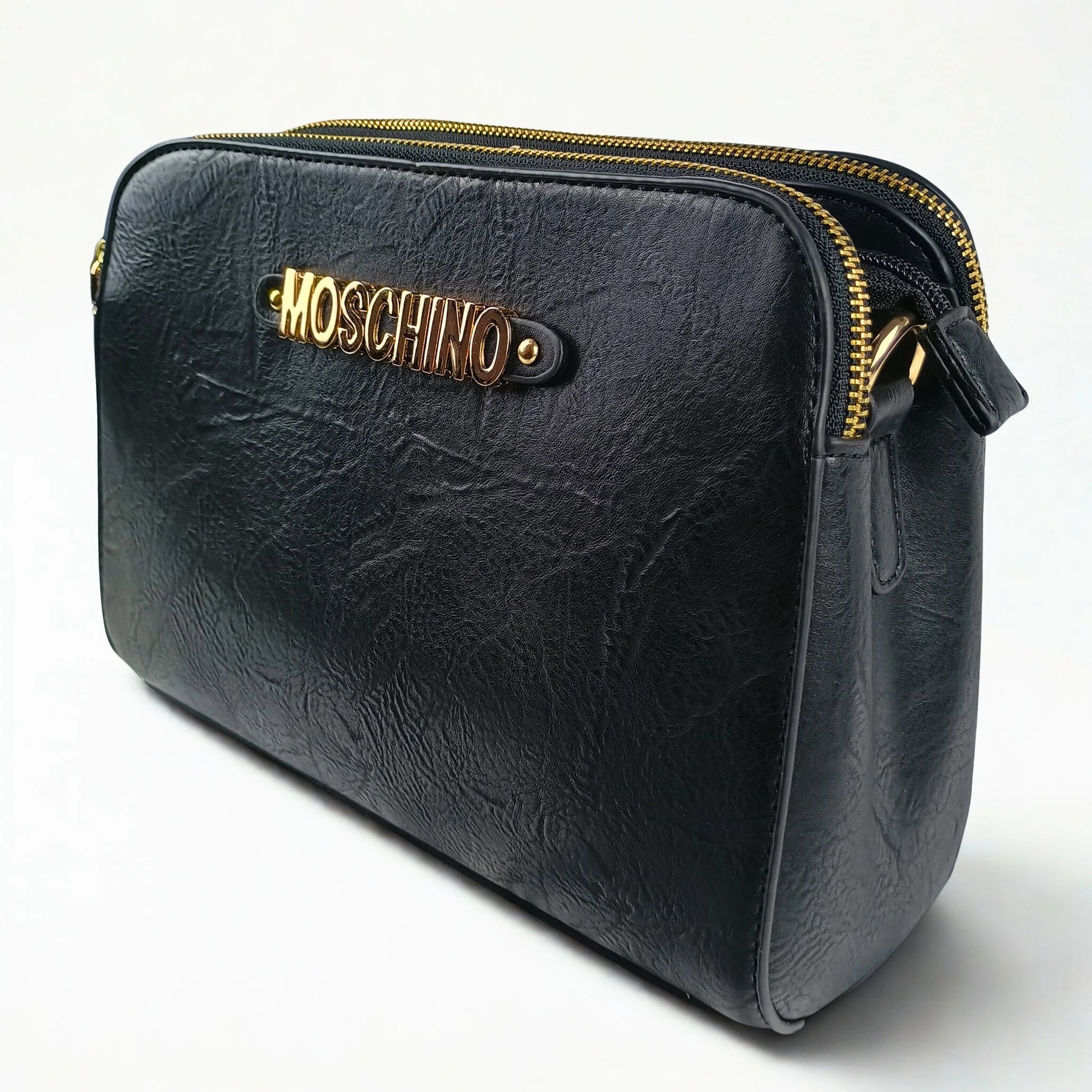 Black leather handbag with gold zipper and Moschino logo on a white background