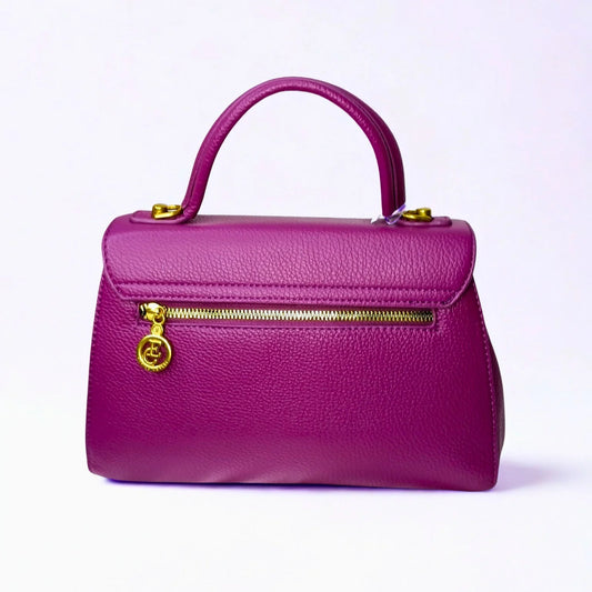 Purple handbag with gold zipper and handle on a light purple background