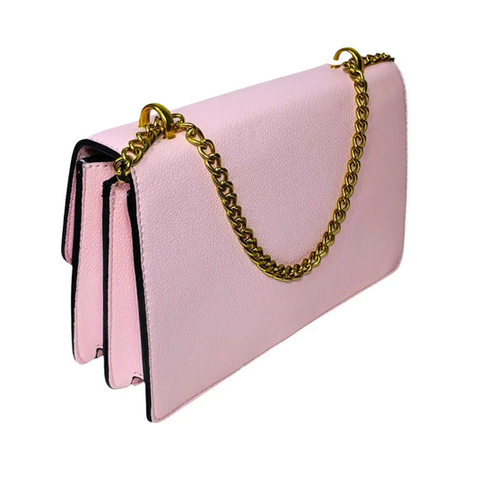 Pink handbag with a gold chain on a light pink background