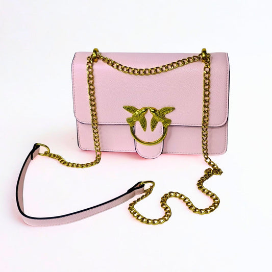 Pink handbag with gold chain strap on a white background